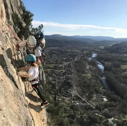 Petite fille et moniteur progressant en via ferrata