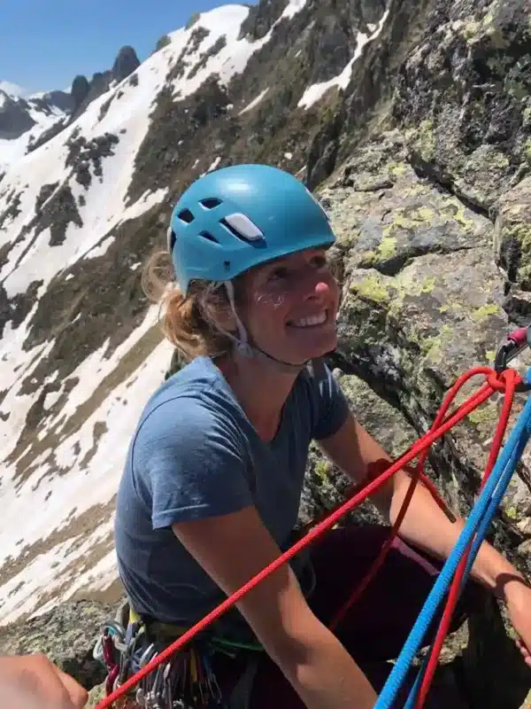 Alpiniste souriante au relais d'une ascension