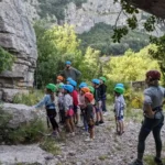 Instructeur en escalade enseignant à des enfants de colonie de vacances au Thaurac
